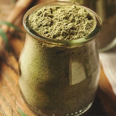 Bright green herbal powder in a glass jar, ideal for cooking and health supplements. Fresh, organic,.